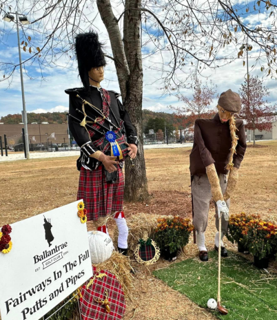A scarecrows dressed as a bagpipe player and another scarecrow dressed as a golfer.