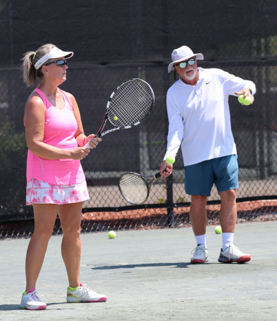 Tennis Pro giving instruction to adult tennis player